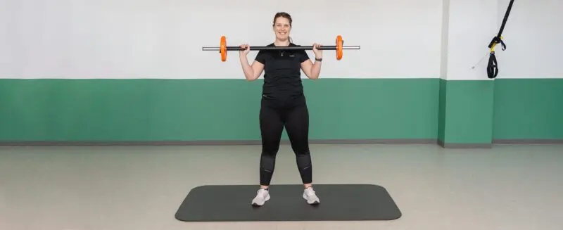 Fysioterapeuten laver squat med bodybar