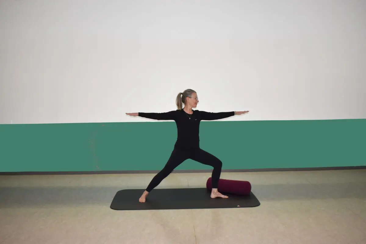 Underviser står i yoga stilling