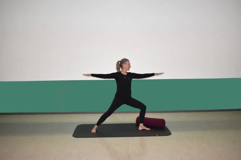 Underviser står i yoga stilling