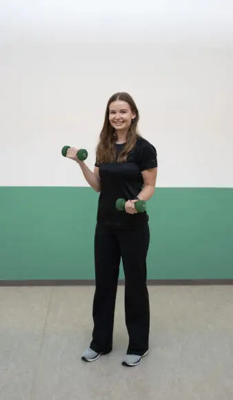 Fysiotepeuten træner biceps med håndvægte
