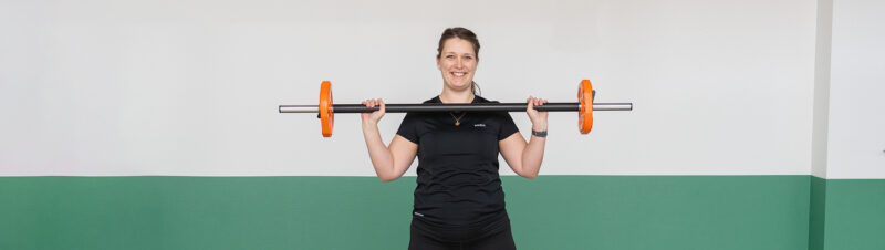 Fysioterapeuten laver squat med bodybar